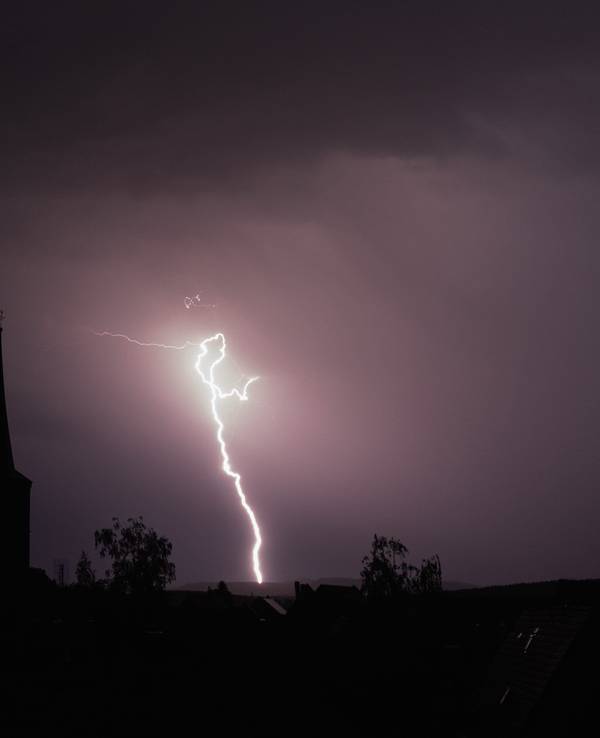 19.05.2022, Bayern, Rattelsdorf: Blitze entladen sich aus einer Gewitterwolke über der Ortschaft.