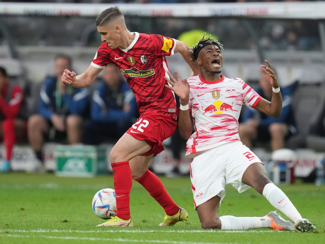 Freiburg's Roland Sallai, left, and Leipzig's Mohamed Simakan fight for the ball during the German Soccer Cup final match between SC Freiburg and RB Leipzig at the Olympic Stadium in Berlin, Germany, Saturday, May 21, 2022. (AP Photo/Michael Sohn)
