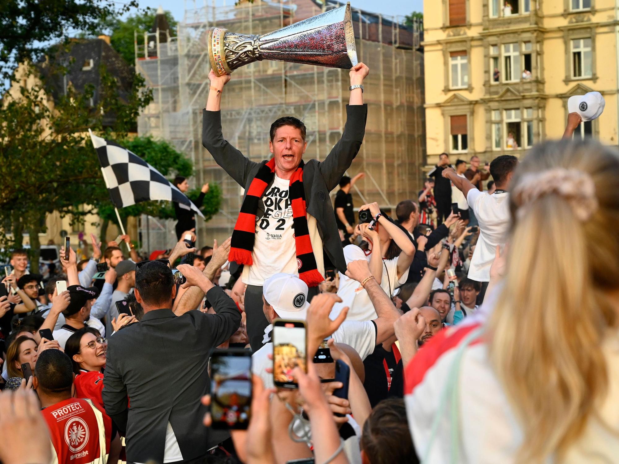 Oliver Glasner reckt den Europapokal bei einem Autokorso in die Luft.