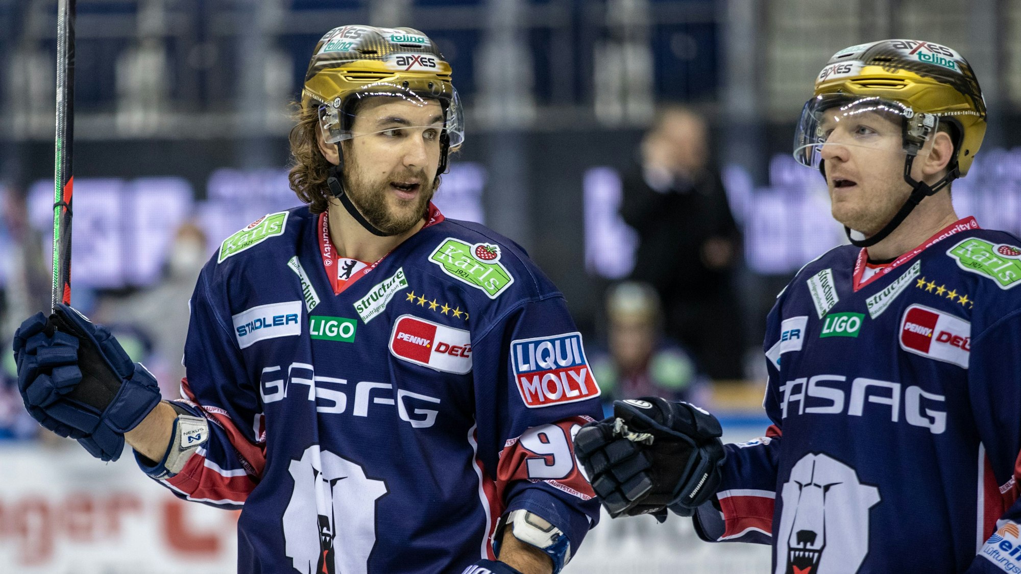 Berlins Kris Foucault (l) und Mark Zengerle laufen über das Eis.