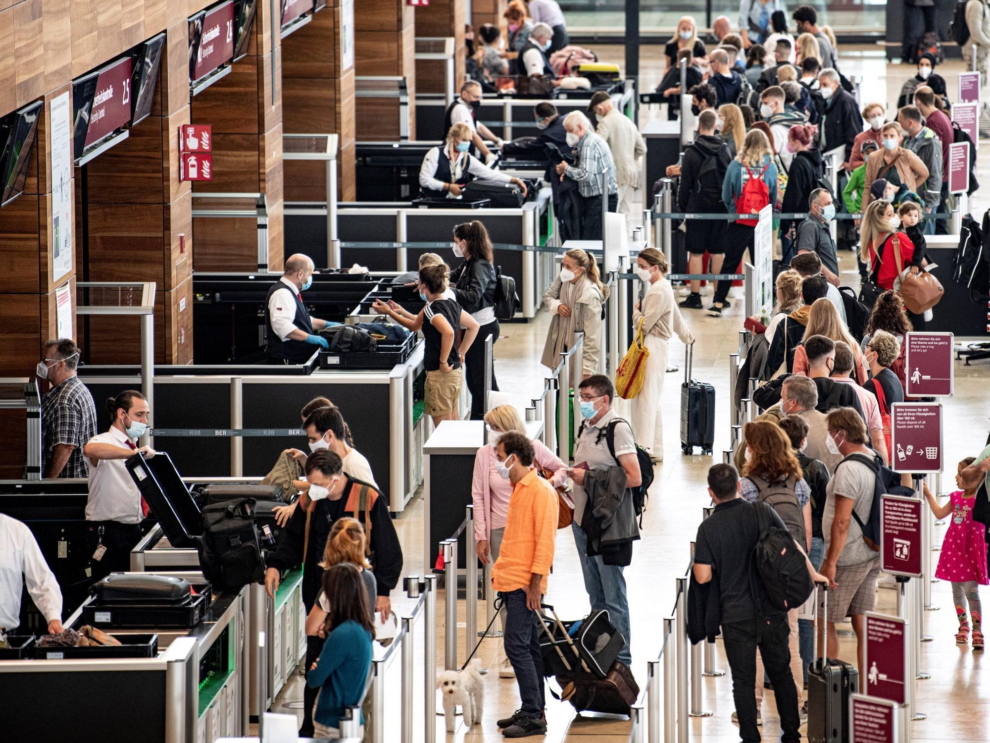 Reisende stehen am Flughafen am Check-In-Schalter.