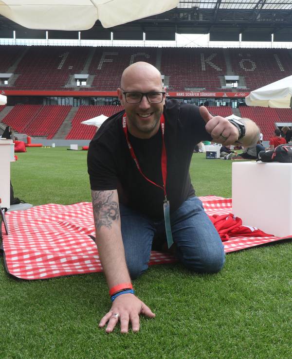 Ein Mann kniet auf dem Rasen in einem Fußballstadion.