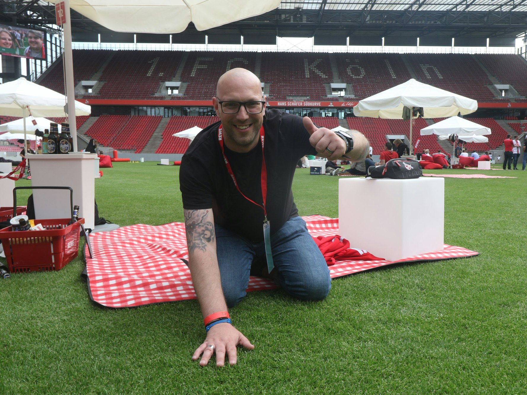 Ein Mann kniet auf dem Rasen in einem Fußballstadion.