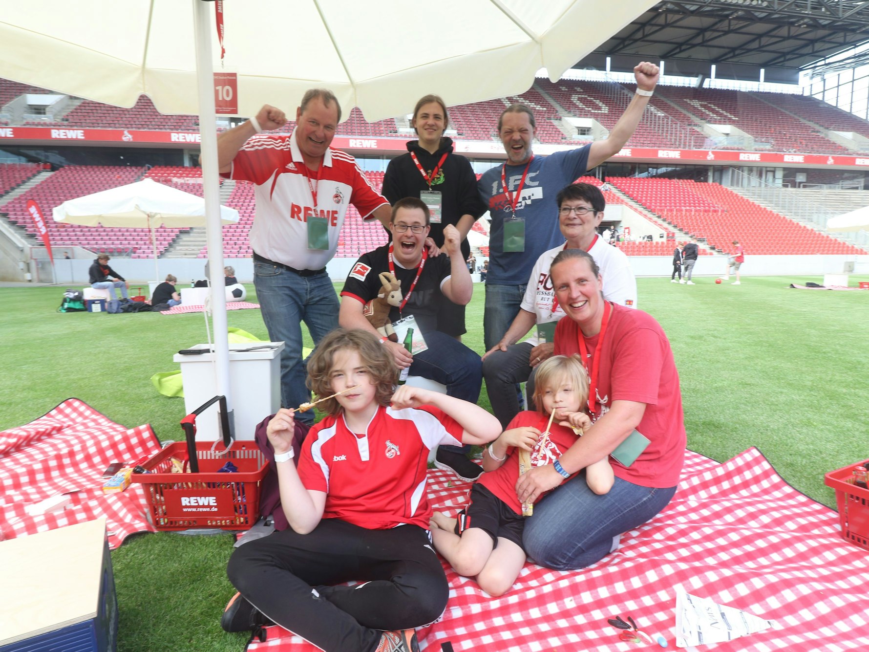 Feiernde Fans auf einem Fußballfeld.