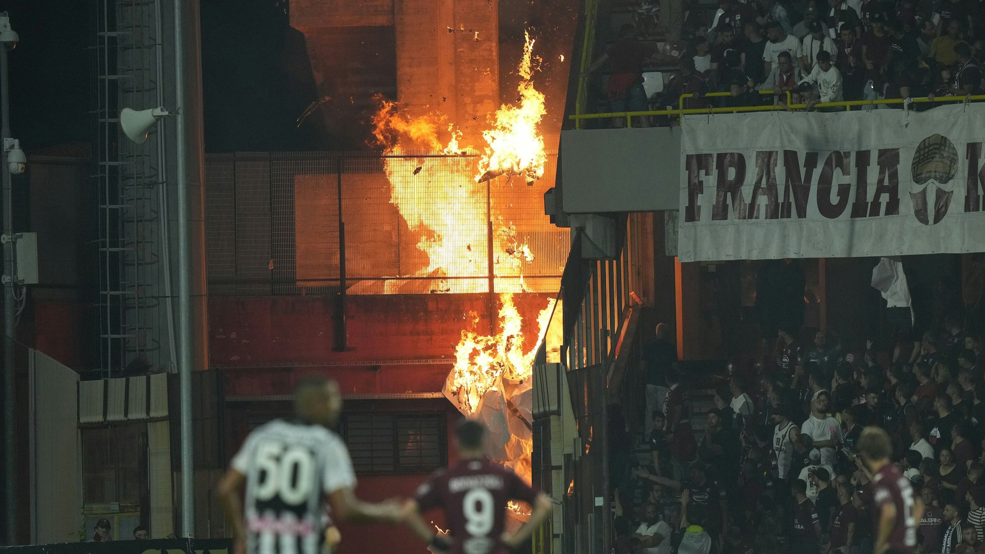 Brennende Gegenstände fliegen im Stadion herum.