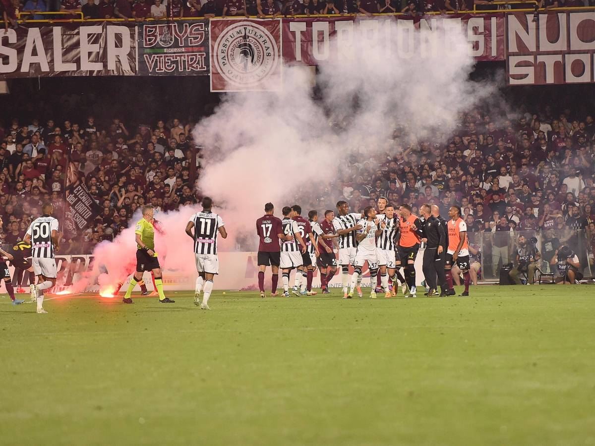 Die von Fans geworfenen Rauchbomben liegen auf dem Spielfeld.