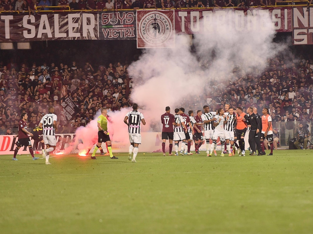 Die von Fans geworfenen Rauchbomben liegen auf dem Spielfeld.