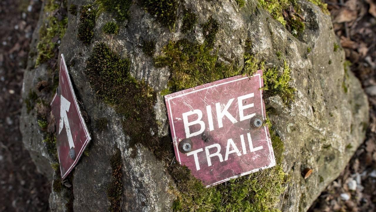 Ein Schild mit der Aufschrift «Bike Trail» (Fahrradweg) liegt auf einer Trail-Strecke in Zürich.