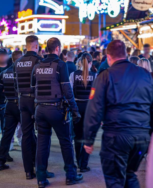 Polizeibeamte gehen über das Kirmesgelände.