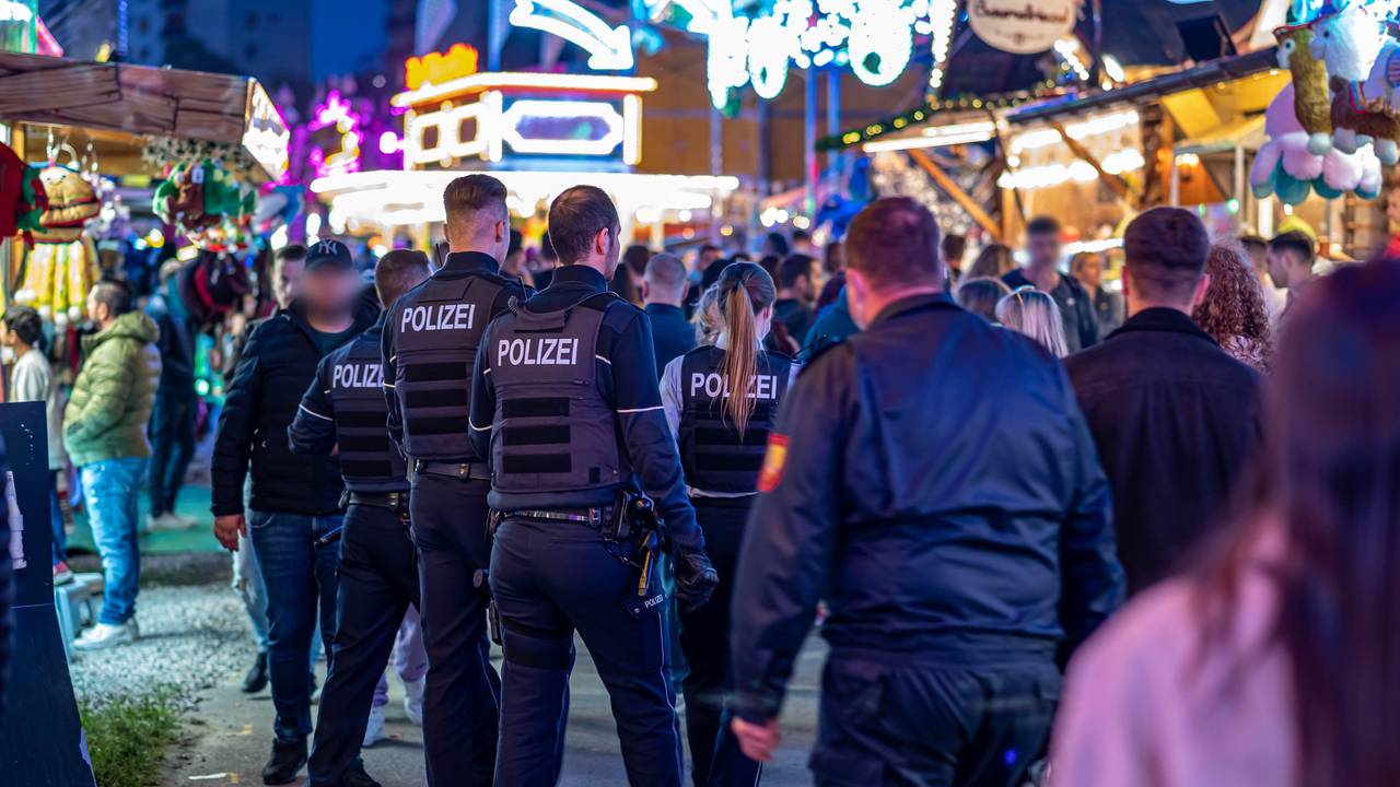 Polizeibeamte gehen über das Kirmesgelände.