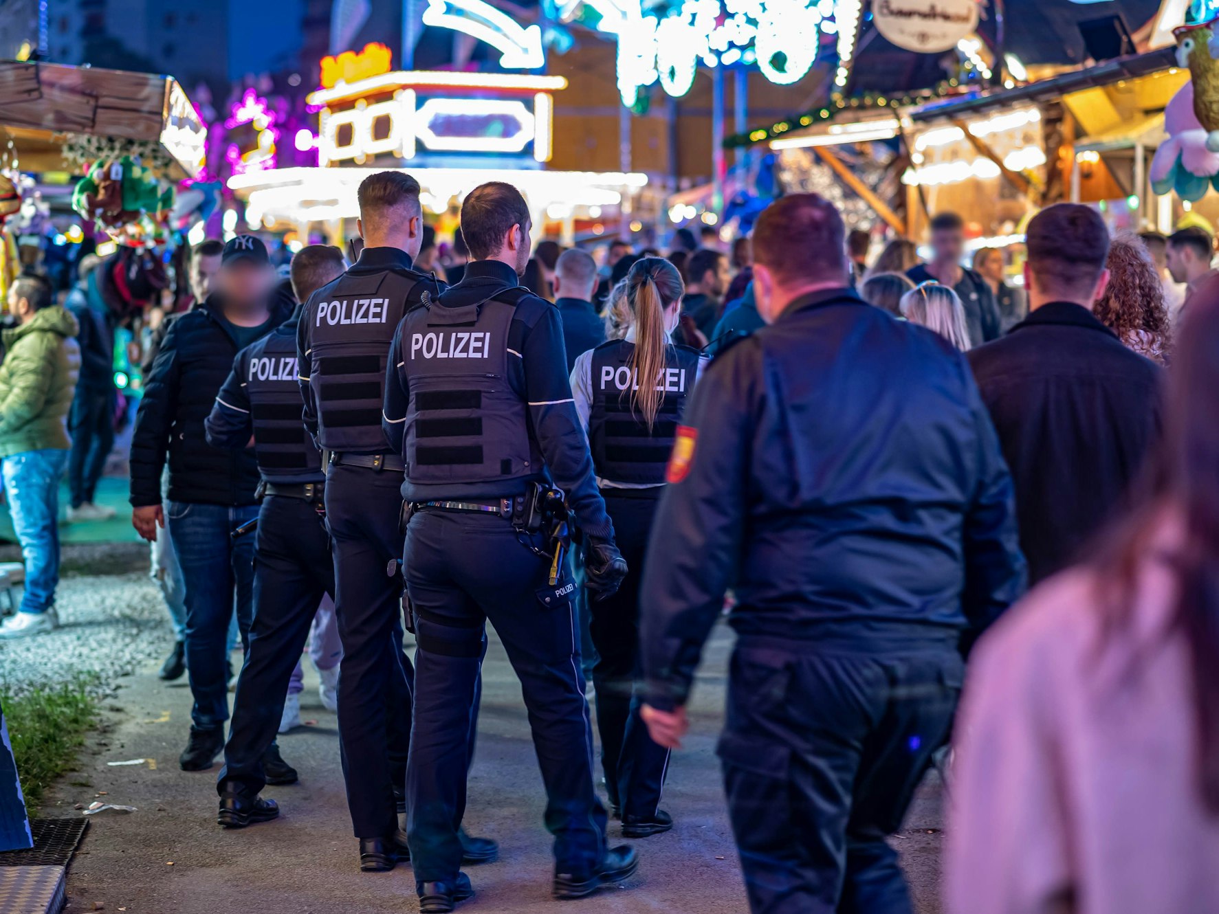 Polizeibeamte gehen über das Kirmesgelände.
