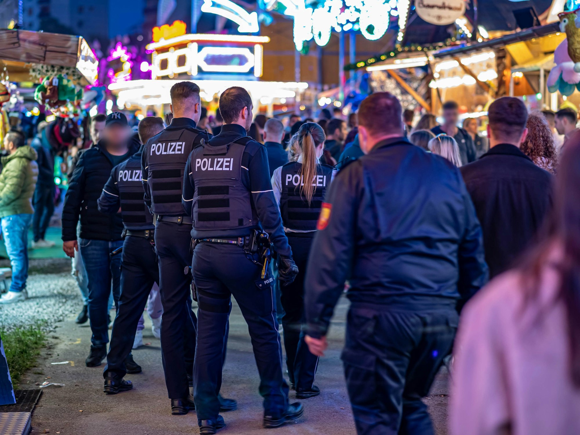 Polizeibeamte gehen über das Kirmesgelände.