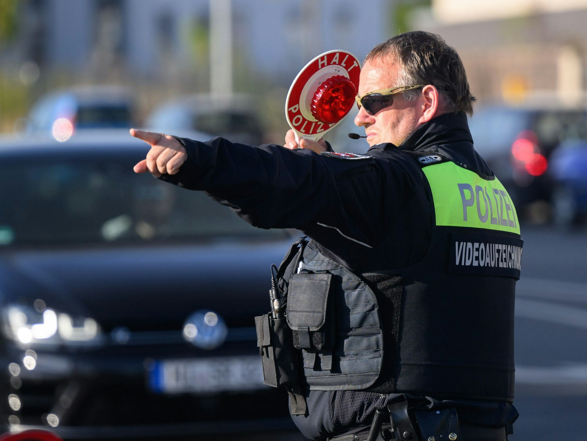 Ein Polizist der Polizei Hildesheim winkt Autofahrer zu einer Kontrolle raus.