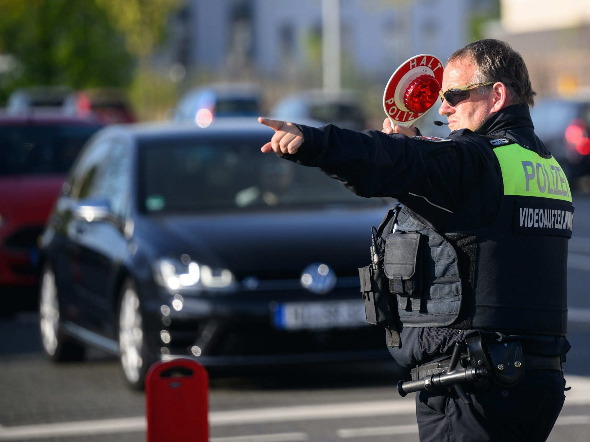 Ein Polizist winkt Autofahrer zu einer Kontrolle raus.