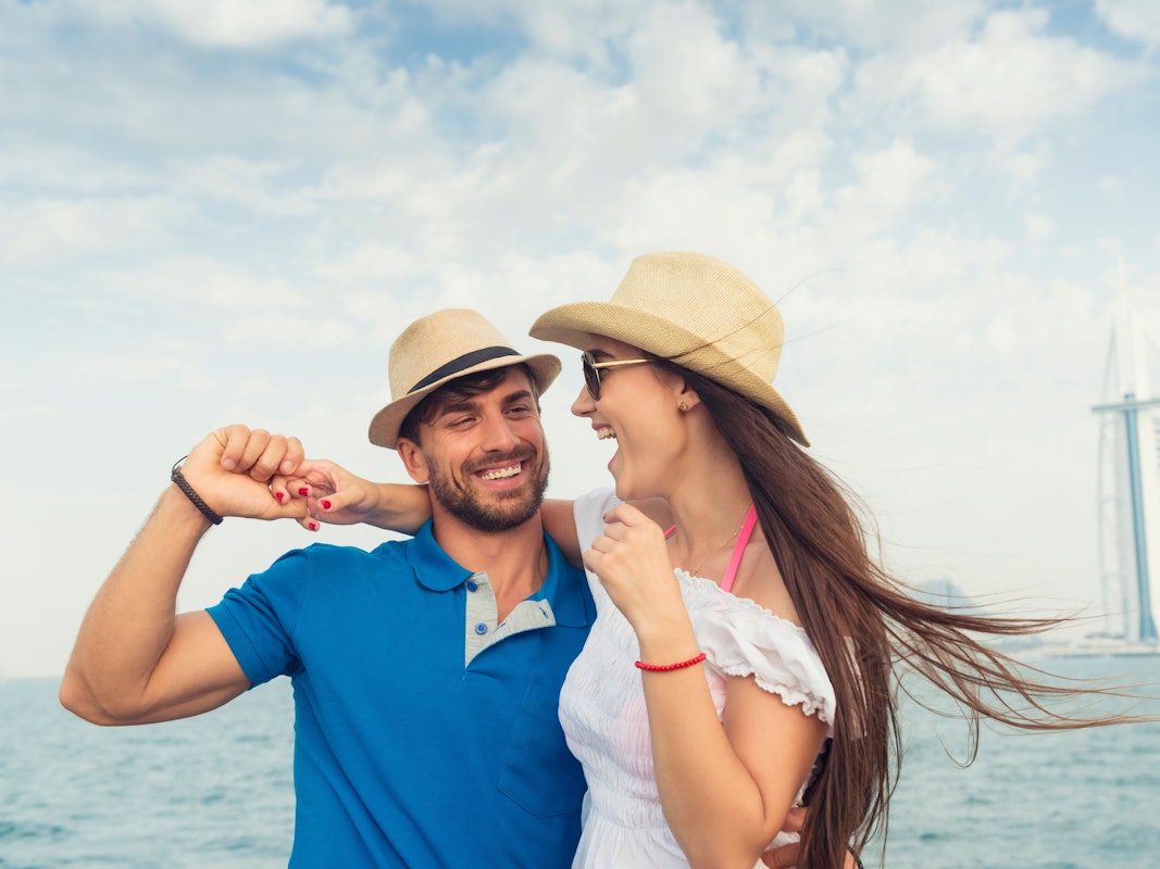 Ein Touristenpaar auf einer undatierten Aufnahme am Strand von Dubai. Im Hintergrund der Burj Al Arab Jumeirah.