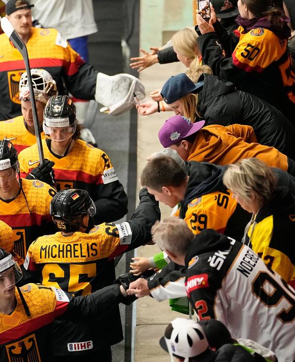 Die deutschen Eishockeyspieler jubeln mit den Fans nach ihrem Sieg.
