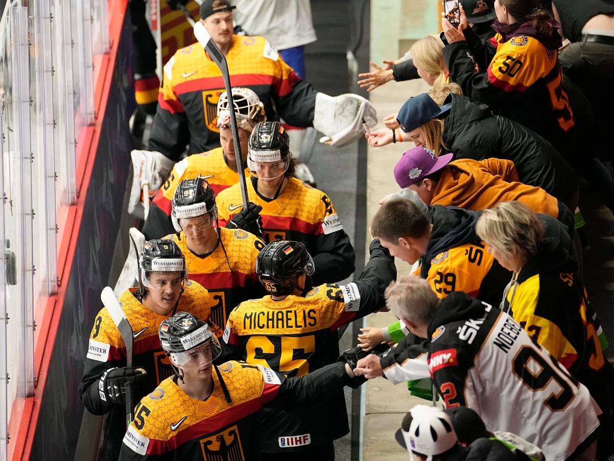 Die deutschen Eishockeyspieler jubeln mit den Fans nach ihrem Sieg.