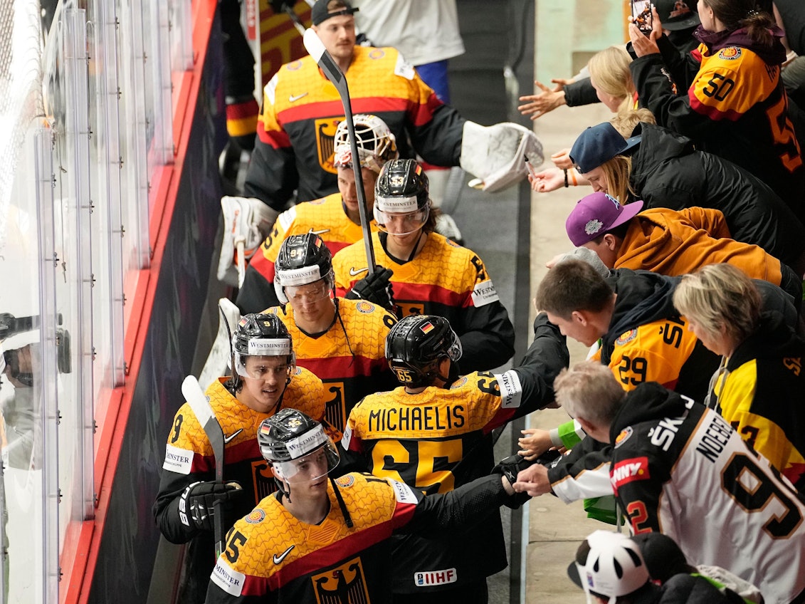 Die deutschen Eishockeyspieler jubeln mit den Fans nach ihrem Sieg.