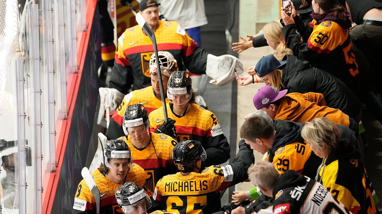 Die deutschen Eishockeyspieler jubeln mit den Fans nach ihrem Sieg.