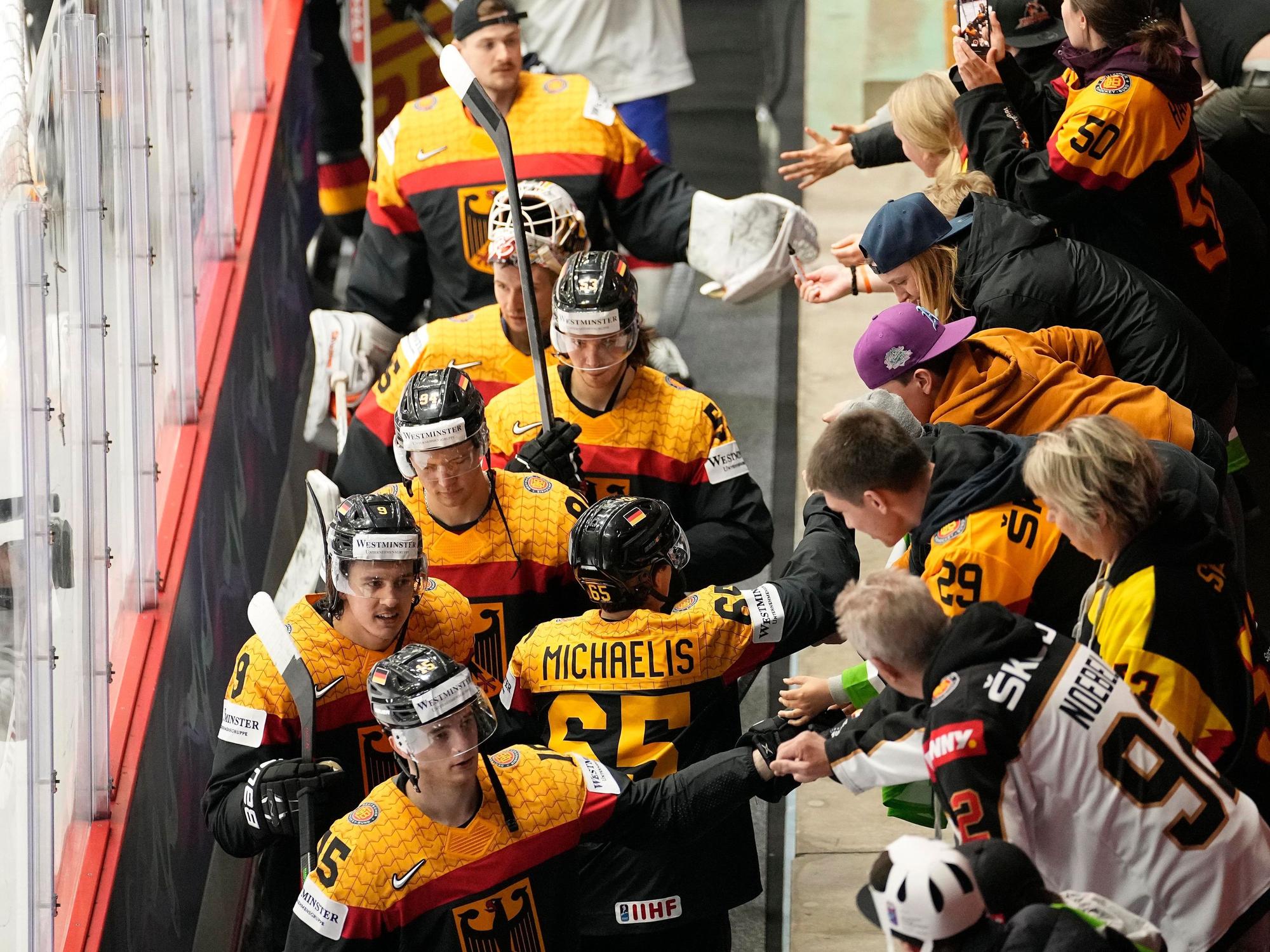 Die deutschen Eishockeyspieler jubeln mit den Fans nach ihrem Sieg.