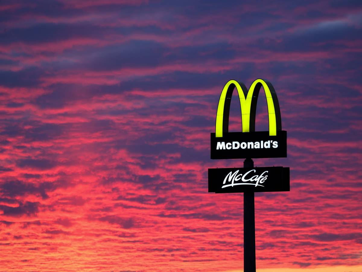 Der Abendhimmel leuchtet rötlich am 30. November 2020 hinter einem McDonalds-Logo.