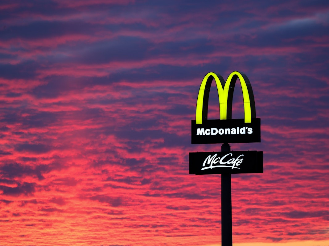 Der Abendhimmel leuchtet rötlich am 30. November 2020 hinter einem McDonalds-Logo.