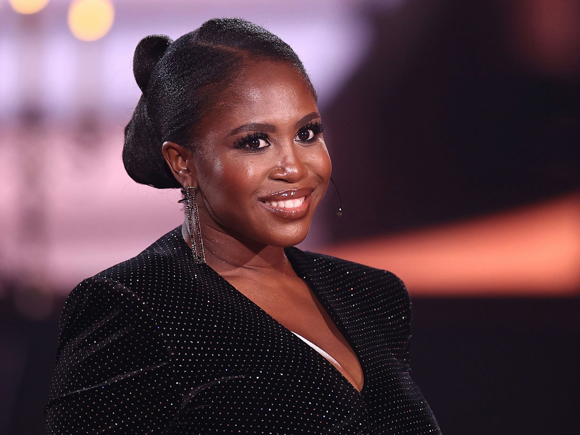 Motsi Mabuse lächelt im Glitzerkleid in die Kamera.