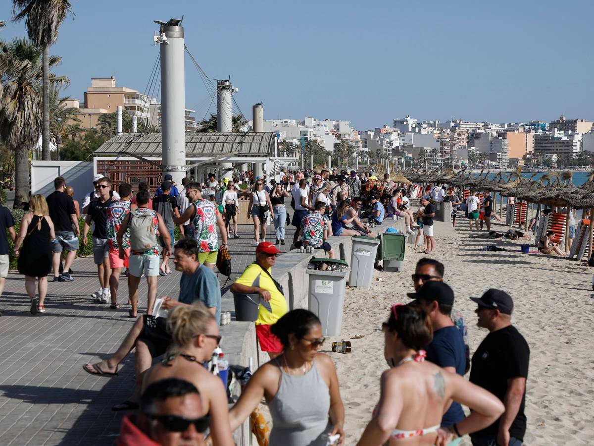 Menschen halten sich am Strand von Arenal in der Abenddämmerung auf.