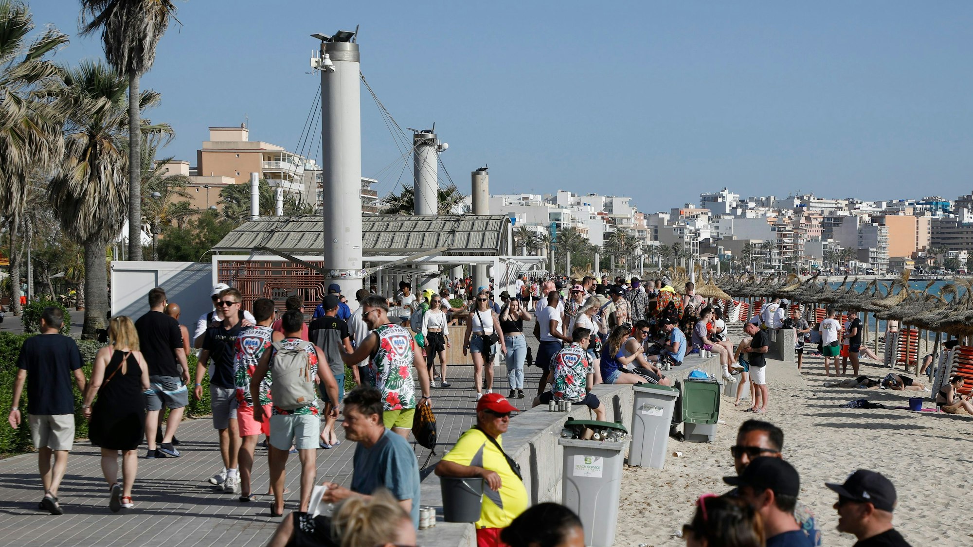 Menschen halten sich am Strand von Arenal in der Abenddämmerung auf.