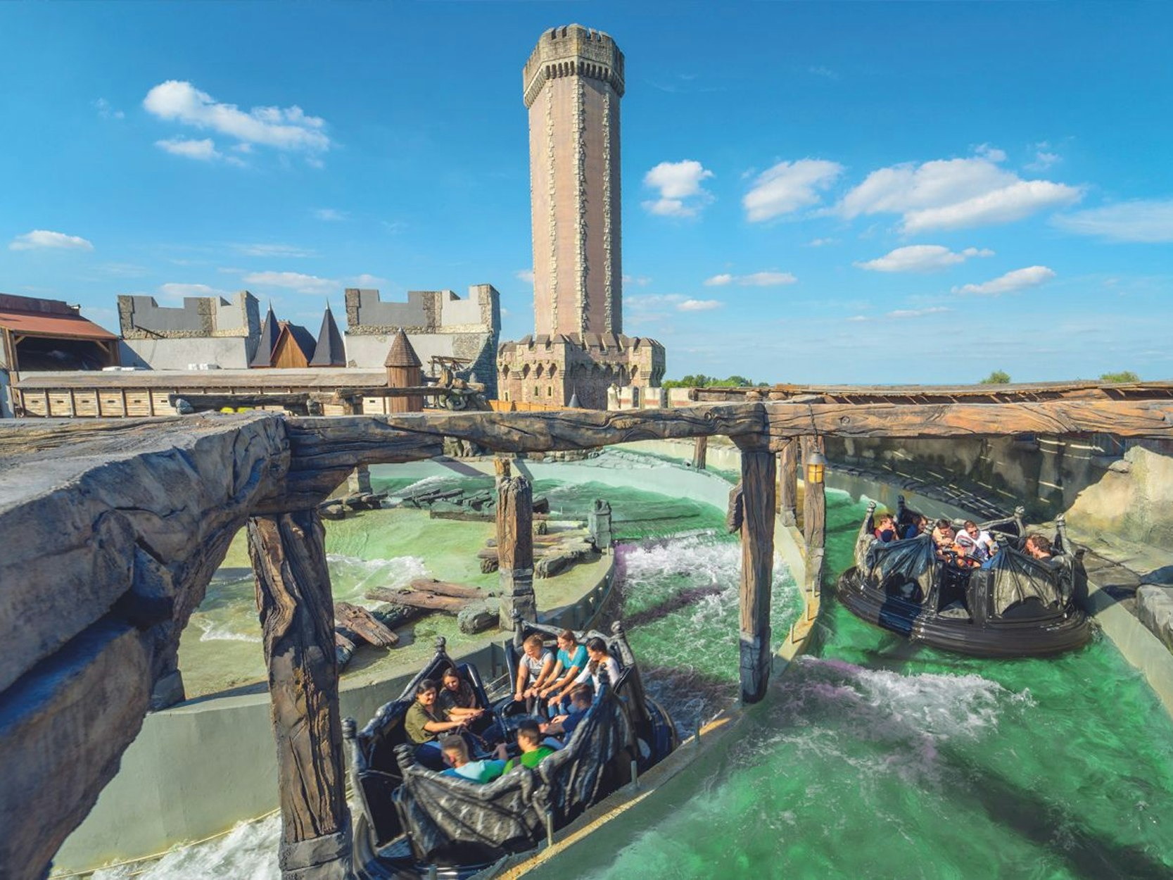 Die Attraktion River Quest im Phantasialand in Brühl. Menschen fahren mit kleinen Booten in Gruppen durchs Wasser.
