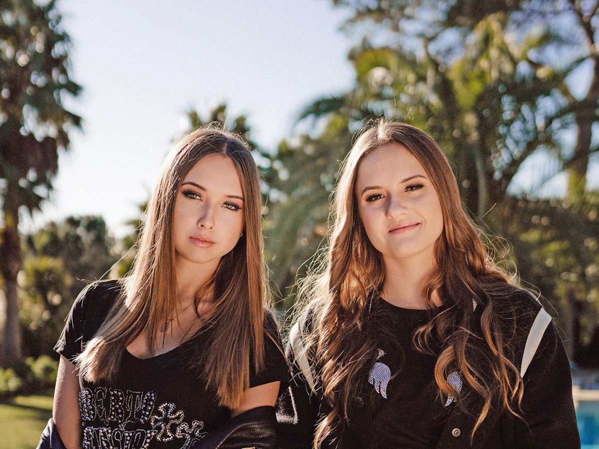 Davina (l.) und Shania Geiss (r.) posieren vor einem Swimmingpool.