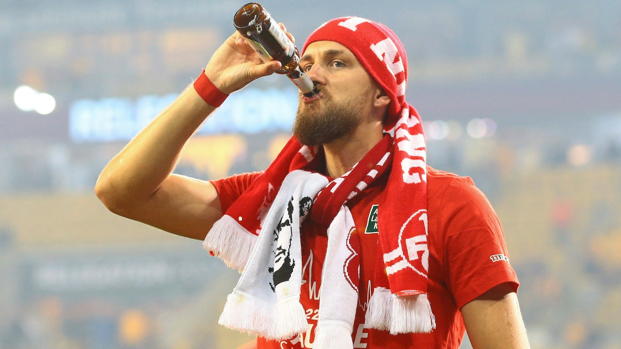 Mit Fan-Schals und einem kühlen Bier in der Hand feiert Mike Wunderlich den Zweitliga-Aufstieg des 1. FC Kaiserslautern.