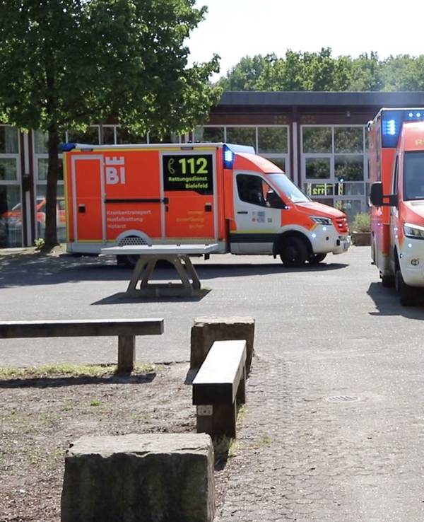 Einsatzfahrzeuge vom Rettungsdienst Bielefeld stehen vor der Schule.