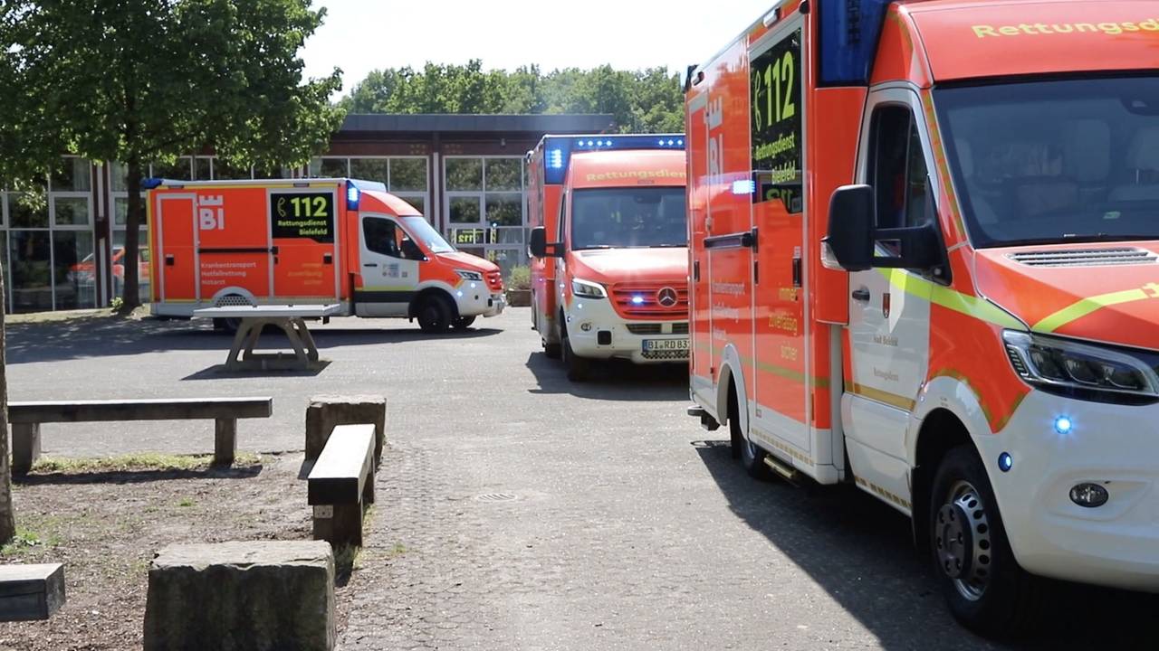 Einsatzfahrzeuge vom Rettungsdienst Bielefeld stehen vor der Schule.
