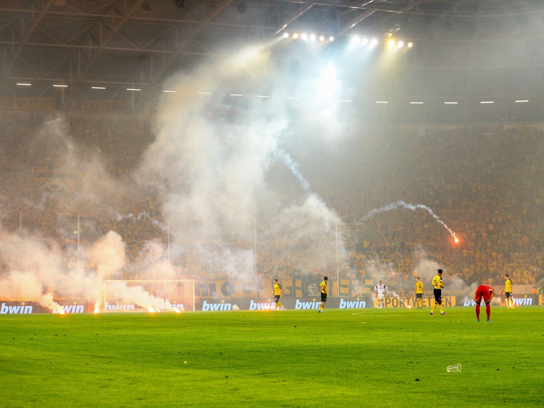 Dresden Fans werfen Pyrotechnik auf das Spielfeld.