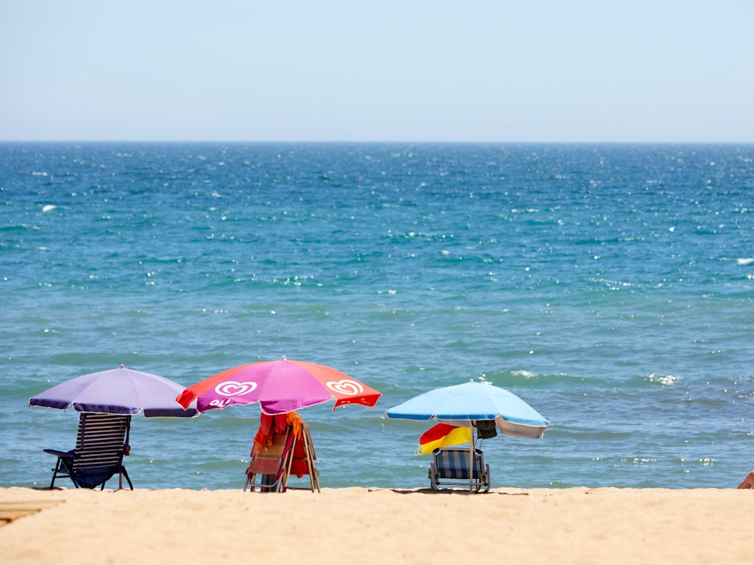 Ein paar Sonnenliegen- und Schirme stehen am 29. Juni 2021 am Strand von Portugal.