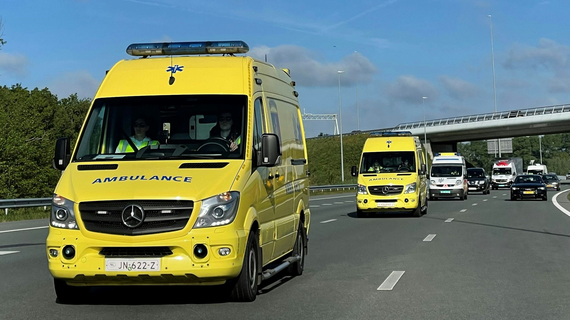 Mehrere Krankenwagen sind auf einer Autobahn unterwegs.