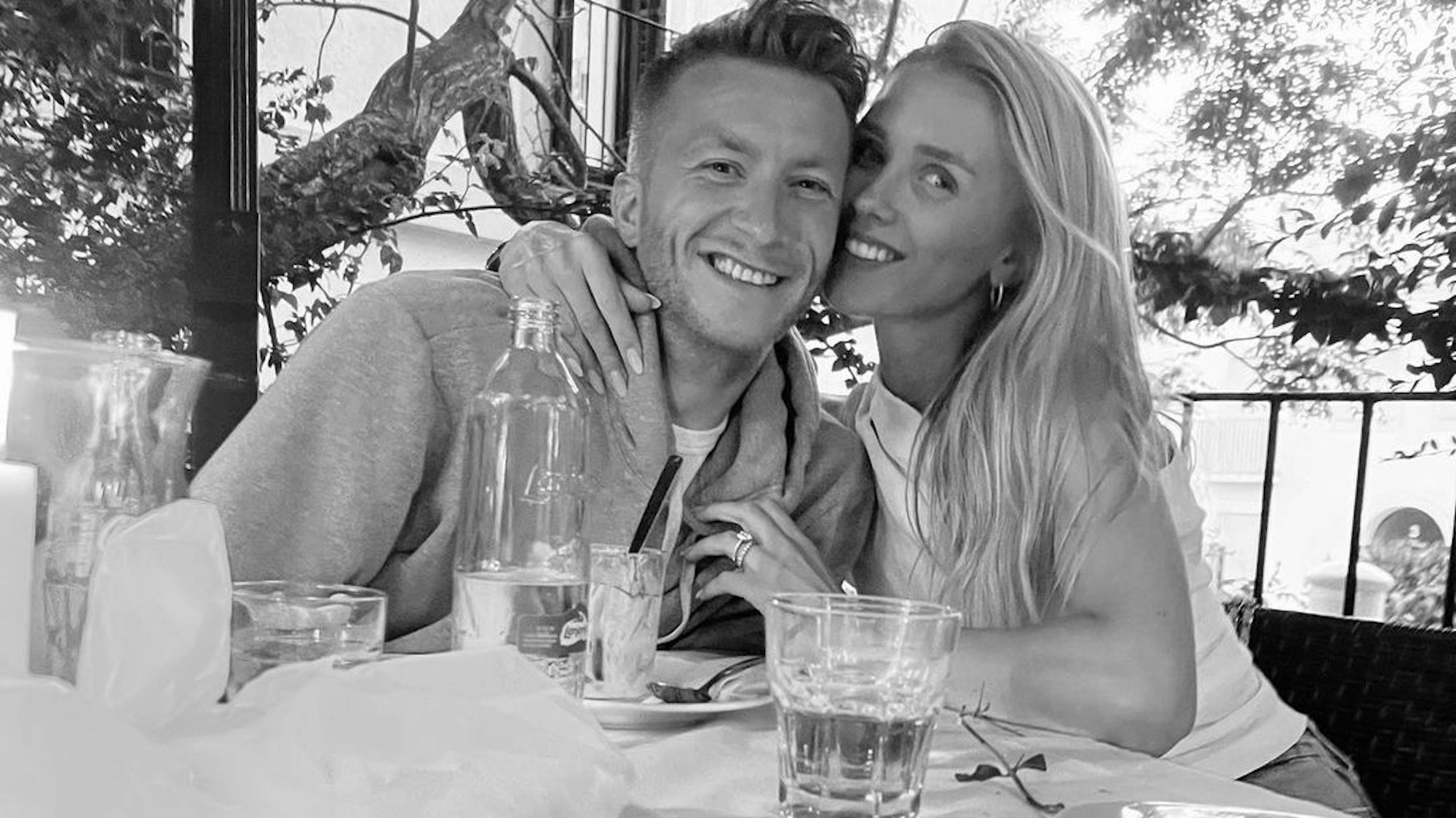 Marco Reus und seine Frau Scarlett sitzen an einem Tisch.