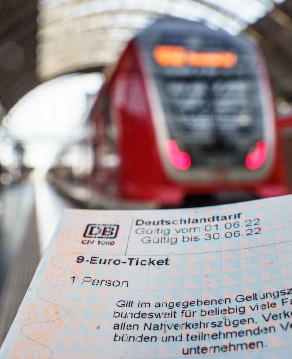 9-Euro-Ticket, das für ein Symbolbild vor einen Zug gehalten wird.