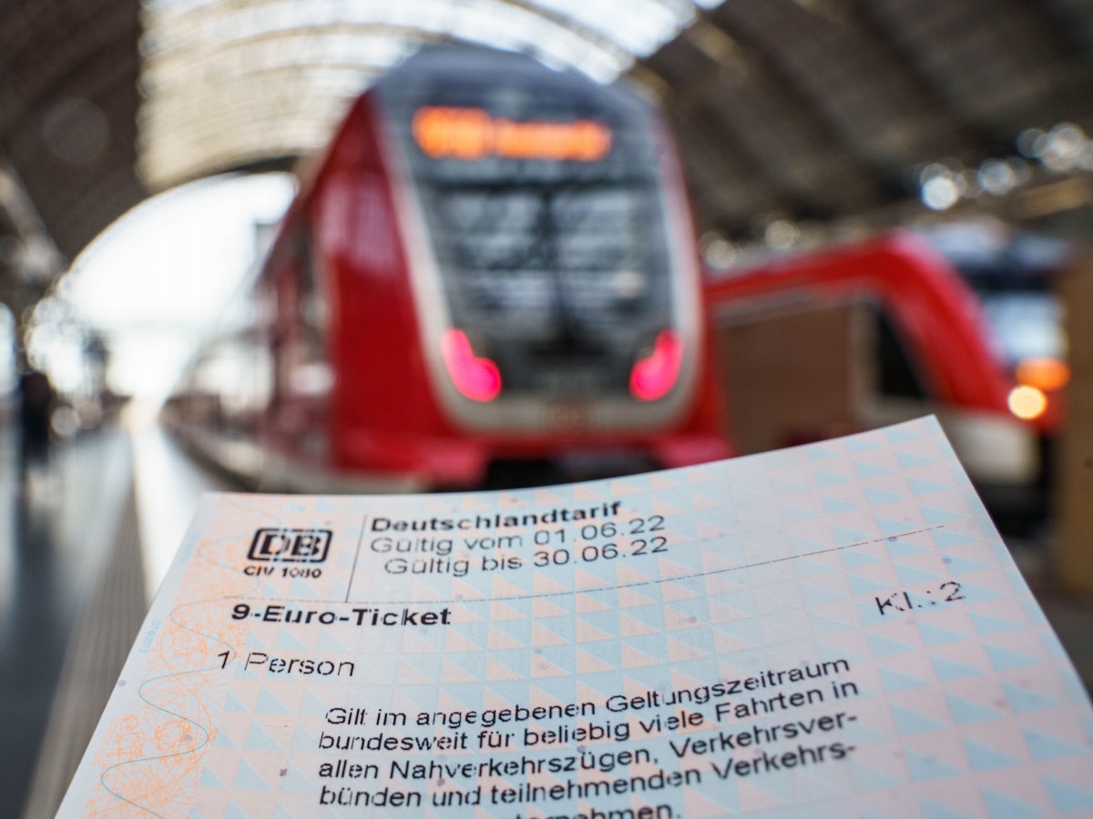 9-Euro-Ticket, das für ein Symbolbild vor einen Zug gehalten wird.
