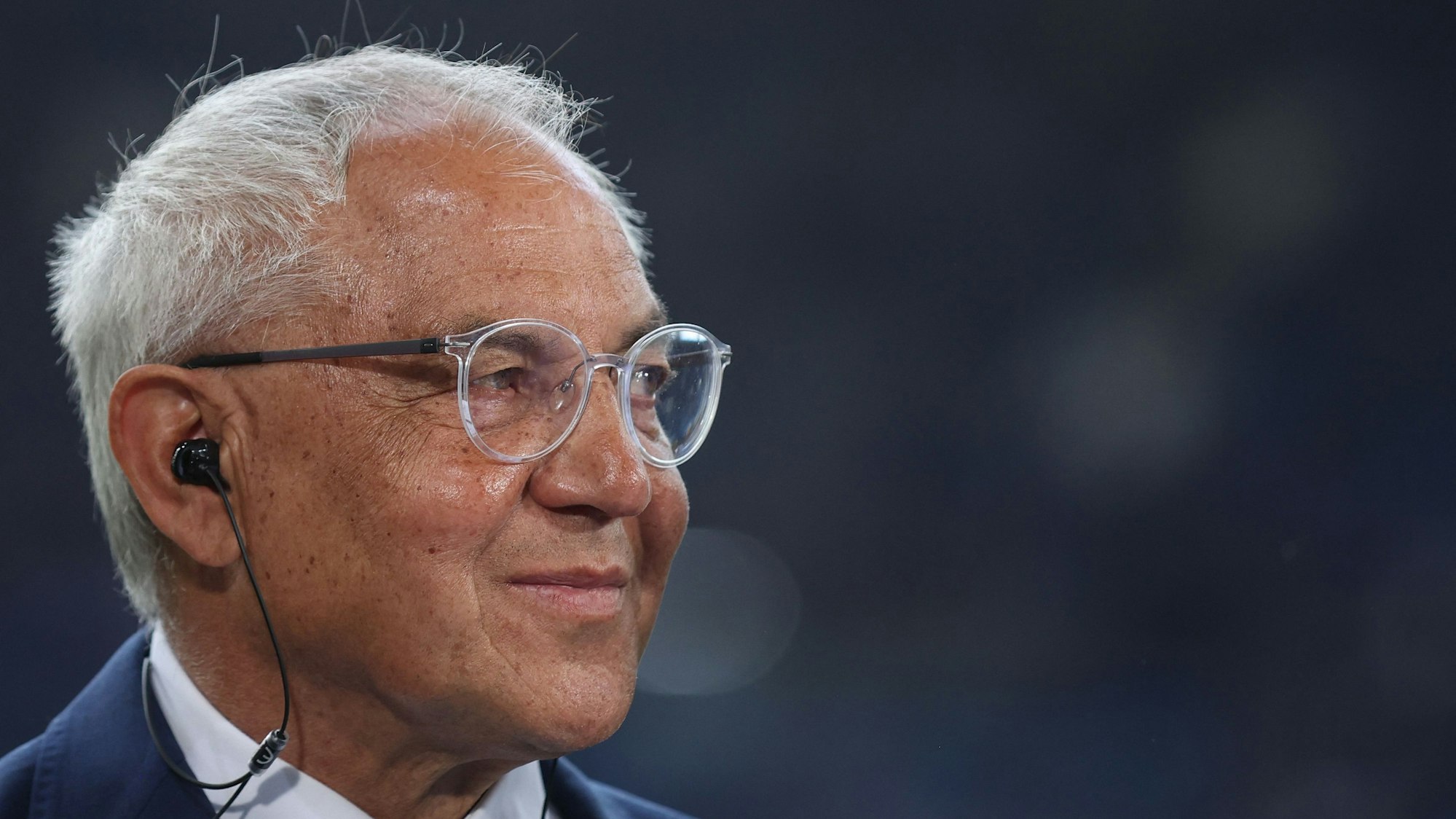 Felix Magath trägt Kopfhörer während eines Interviews.