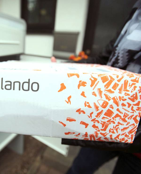 Eine Frau hält in Königswinter (Nordrhein-Westfalen) ein Paket des Online-Versandhändlers für Schuhe und Mode, Zalando.