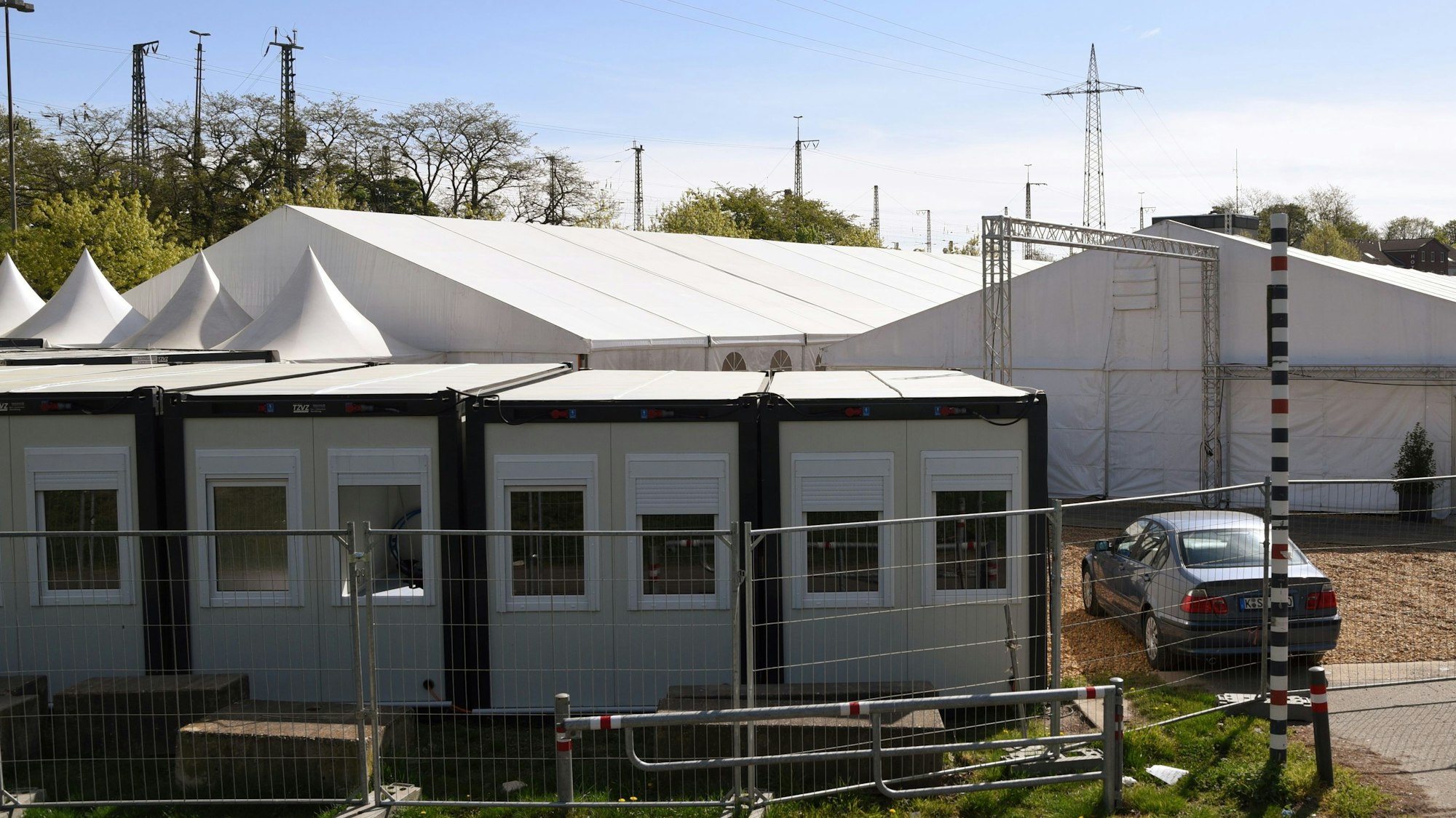 Mehrere Wohncontainer stehen vor großen Zeltunterkünften.