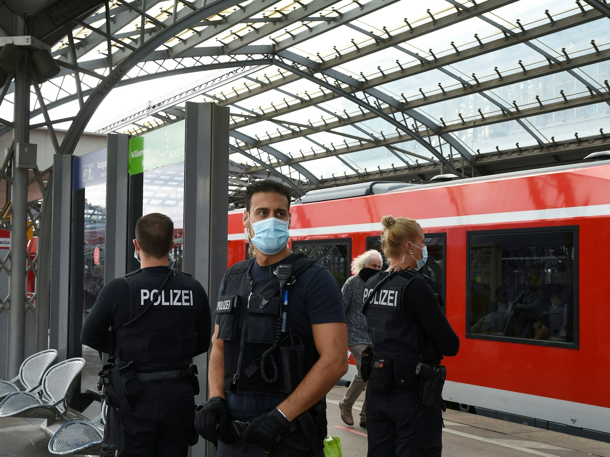 Drei Einsatzkräfte stehen an einem Gleis im Kölner Hauptbahnhof.