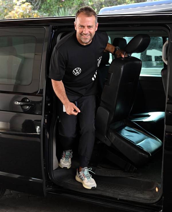 Bundestrainer Hansi Flick springt aus einem Kleinbus.