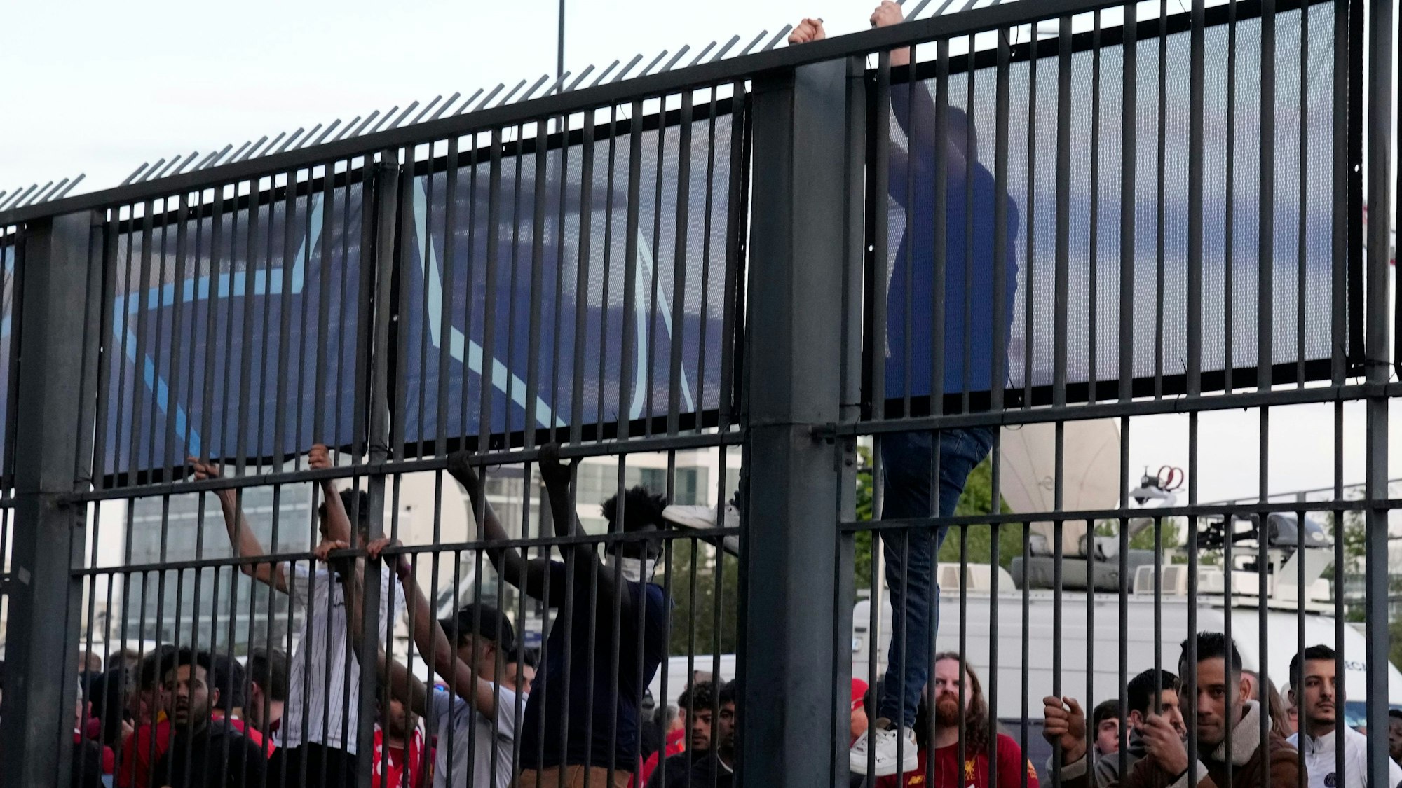 Ein Fan klettert an einem Zaun des Stadions in Paris hoch.
