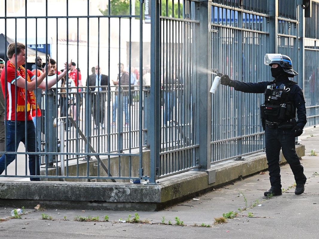 Szenen rund um das Stadion: Ein Polizist sprüht Tränengas.