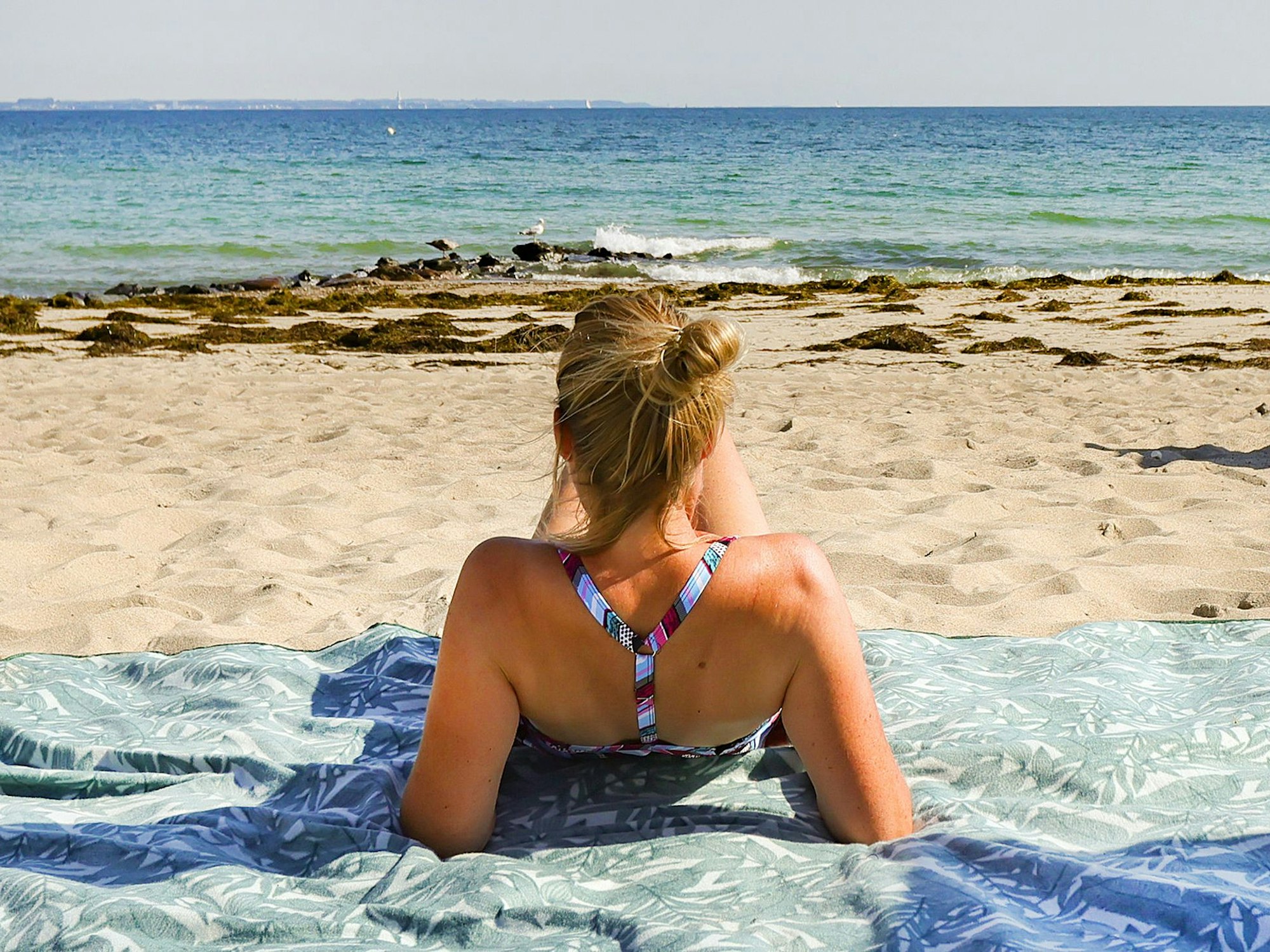 In diesem Sommer wollte die Reisebranche sich aus der Corona-Krise katapultieren, doch dann kam der Krieg. Die Preise klettern auch hier deutlich nach oben, ein Ende der Verteuerung ist noch nicht absehbar. Unser Archivfoto (2021) zeigt eine Urlauberin am Timmendorfer Strand.