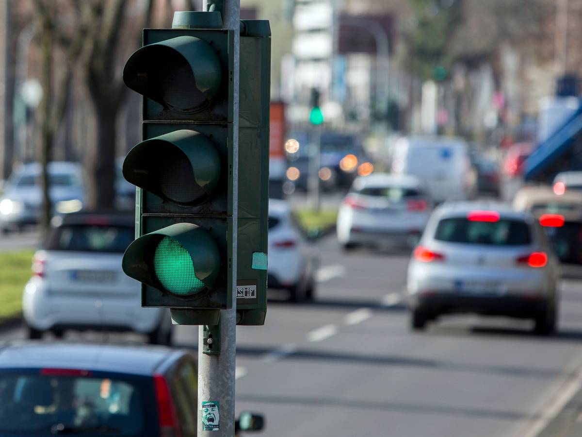 Eine Ampel in Köln, im Hintergrund der rollende Verkehr.