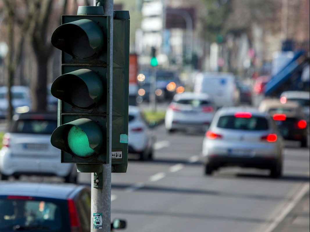 Eine Ampel in Köln, im Hintergrund der rollende Verkehr.